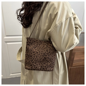 Borsa a secchiello leopardata con tracolla marrone indossata sopra un trench beige lungo