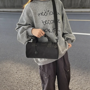 Sac de sport cylindrique noir en toile avec bandoulière réglable au style décontracté