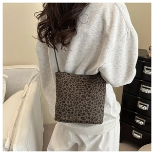 Détail du sac seau à motif léopard avec texture en daim et fine bandoulière en cuir