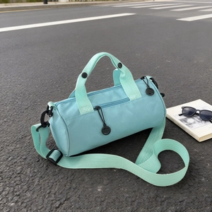 Light blue cylinder travel bag with mint green straps and adjustable shoulder strap