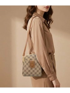 Close-up of a mini crossbody phone bag with geometric patterns and leather trim detail