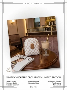 Detail of white checkered vegan leather crossbody bag with adjustable strap in cafe setting