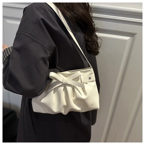 Détail du sac à bandoulière blanc crème avec grand nœud et pendentif étoile argenté