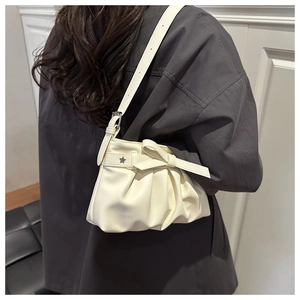 Détail du sac fourre-tout plissé blanc crème avec nœud et œillets en étoile sur la bandoulière