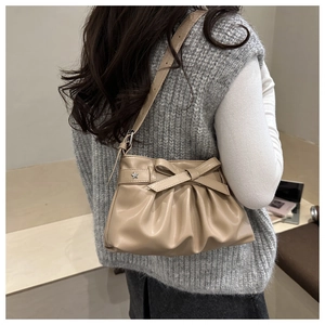 Sac bandoulière plissé beige avec nœud et détail étoile argentée sur modèle