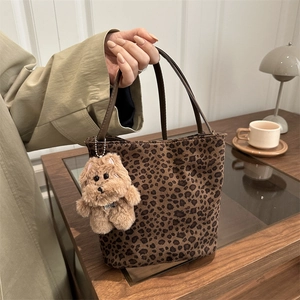 Sac cabas à motif léopard marron avec breloque chien en peluche dans un cadre chaleureux