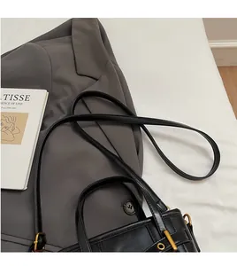 Detail of adjustable black leather strap and gold hardware on a minimalist bucket bag