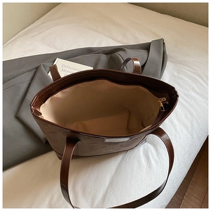 Detail view of large dark brown tote bag with zipper closure and spacious interior