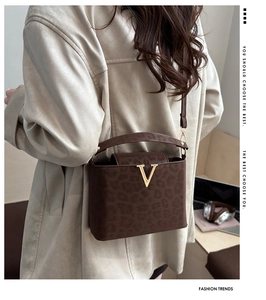 Detail of leopard print crossbody bag with gold V hardware in a lifestyle setting