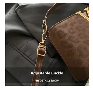 Detailed view of the adjustable golden buckle on the leopard print faux suede strap