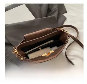 Detail view showing spacious interior with zipper pocket of the brown matte shoulder bag
