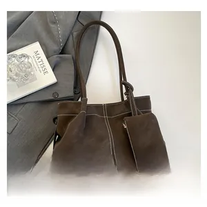 Detailed view of dark brown tote bag with contrast stitching and small zip pouch attached