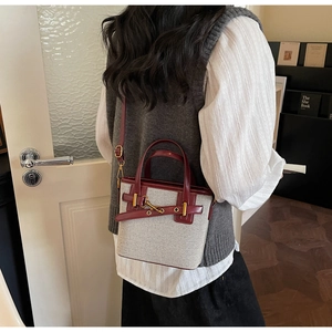 Detail of vintage canvas and leather crossbody bag shown on model in cozy indoor setting