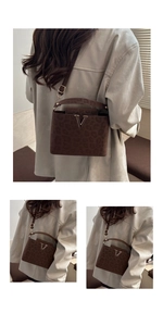 Detail of leopard print suede crossbody bag with gold V-shaped metal logo and slim strap
