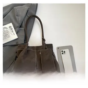 Detail of dark brown tote bag with contrast stitching and matching inner pouch