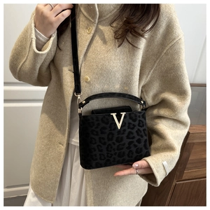 Detail of black leopard print bag with golden V-logo and premium matte texture