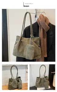Detail view of large dark green suede tote bag with contrast stitching and matching pouch