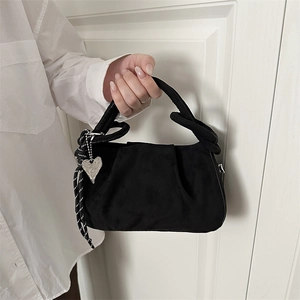Détail du sac à main noir plissé avec poignée épaisse et pendentif en cœur argenté