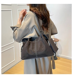 Detail view of suede shoulder bag with white contrast stitching and matching coin purse