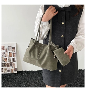 Detail of olive green pleated tote bag with white contrast stitching and matching pouch