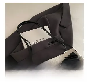 Detail of white tote bag with black bow print and large faux leather bow ornament