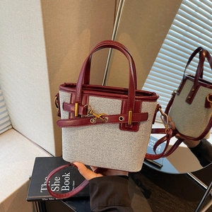 Chic burgundy and beige canvas bucket bag with leather trim and gold metal hardware
