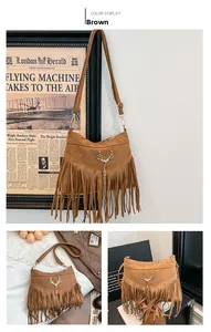 Détail du sac bandoulière en daim marron avec emblème tête de cerf dorée et longues franges