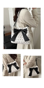 Detail of seersucker tote bag with black bow embroidery and large leather bow accent
