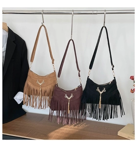 Gros plan de sacs à bandoulière à franges bohèmes en trois couleurs et boucles cerf