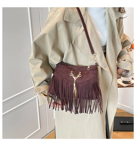 Détail du sac à bandoulière vintage avec franges et breloque tête de cerf dorée