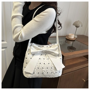 Detailed view of the white bow tote bag featuring textured jacquard and bow embroidery