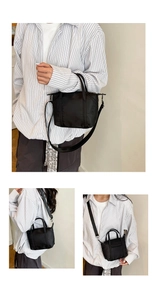 Detail of black nylon tote bag with adjustable shoulder strap and sturdy top handles