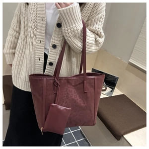 Detail of burgundy leopard embossed tote bag with matching zipper coin purse