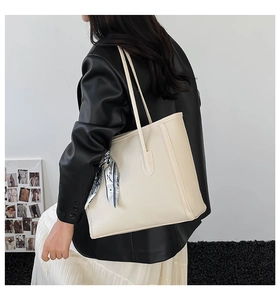 Dettaglio della borsa tote bianco crema con trama litchi e foulard in seta blu France