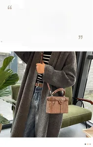 Close-up of a brown vintage box bag featuring denim-style stitching and metal twist lock