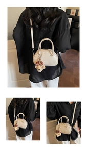 Détail du mini sac baguette blanc crème avec breloque ours en peluche et bandoulière