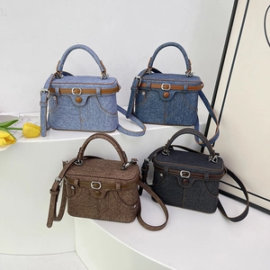 Detail view of denim texture box bags with belt accents and vintage buttons in four colors