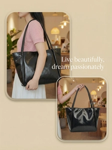 Detail of glossy black leather tote bag showing smooth texture and long shoulder straps