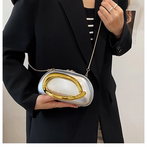 Detail of silver pearl sheen clutch with golden oval clasp and fine chain strap