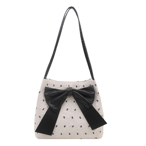 Chic cream tote bag with black mini bows and a large central bow detail on shoulder strap