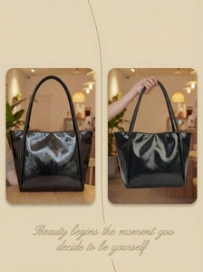 Detail of a large black patent leather tote bag in a cozy cafe setting with glossy finish