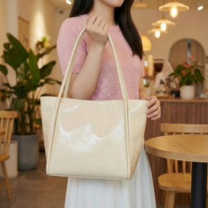 Chic beige patent leather tote bag with a high-gloss finish for stylish women commuters