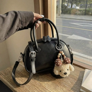 Sac bowling noir élégant avec breloque peluche sur un rebord de fenêtre ensoleillé