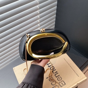 Chic black evening clutch bag with oversized gold circular handle and crossbody chain strap