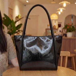 Minimalist black glossy leather tote bag with ample capacity for daily commuting