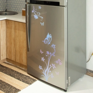 Close-up of luminous butterfly and vine floral wall stickers on a refrigerator door
