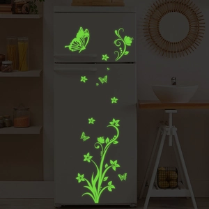 Luminous green butterfly and floral vine wall stickers glowing on a white fridge door