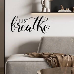 Minimalist JUST breathe wall sticker decal applied above a modern living room sofa