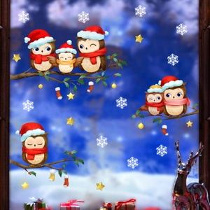 Close-up of Christmas owl and snowflake static window stickers on glass for home decor