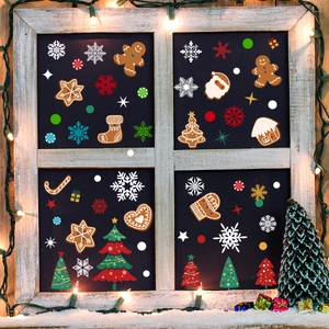 Christmas tree and gingerbread man static glass stickers on wooden window with warm lights